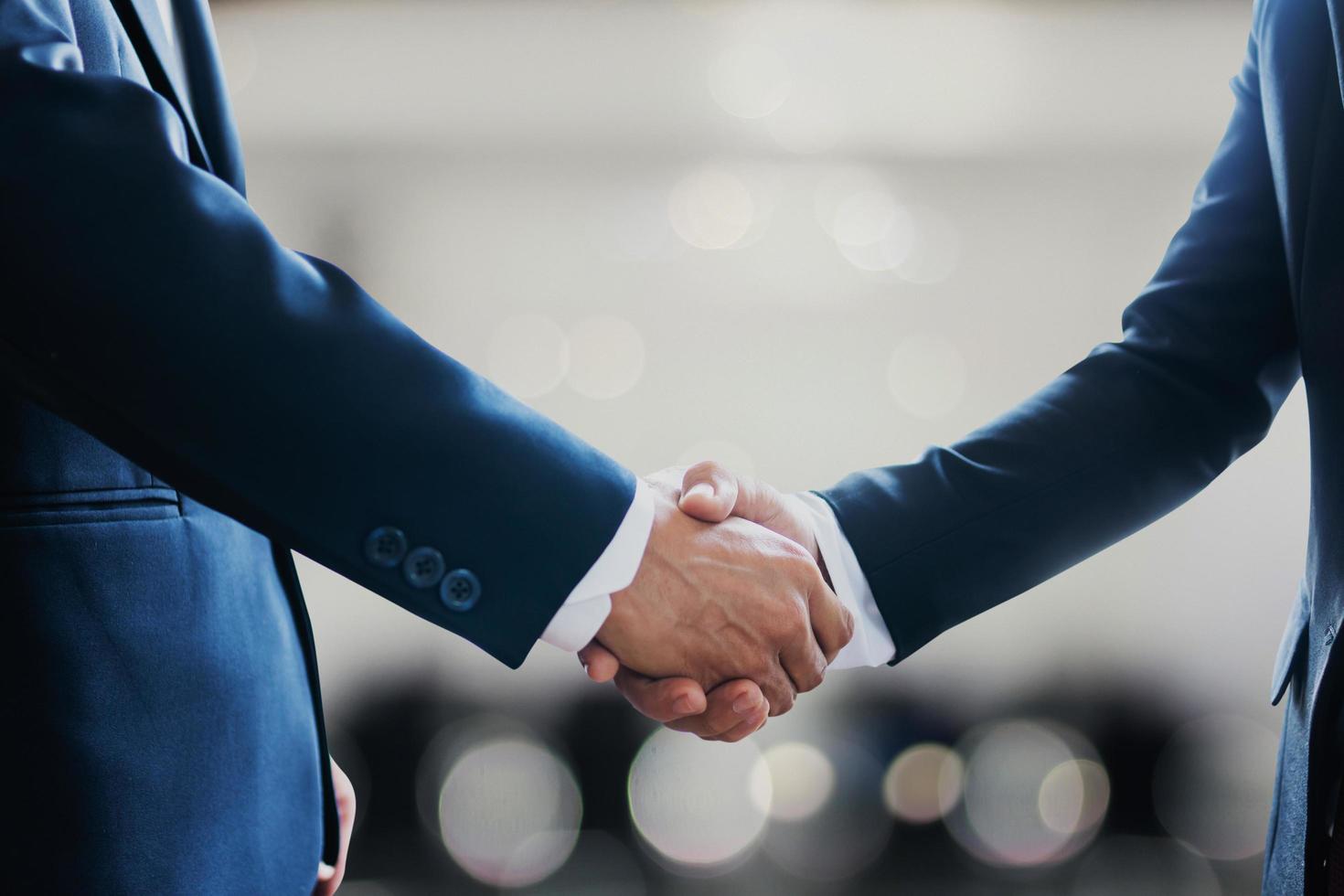 portrait-of-two-businessmen-shaking-hands-to-celebrate-partnership-free-photo